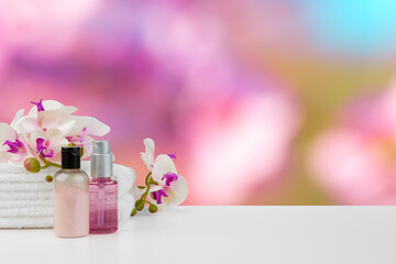 Towels with flowers on light table against blurred background