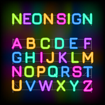 Latin alphabet made of glowing neon letters on a black background. Fluorescent letter with white bulbs in two rows. Multicolor led lamps for advertising or signage.