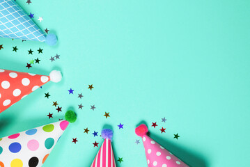 Obraz premium Colorful birthday caps on a blue background. Top view.