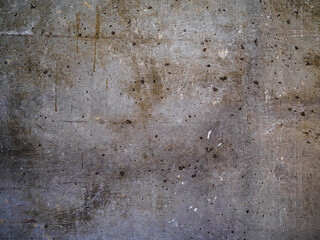 Textured concrete background with many potholes, scratches, irregularities, scuffs with colored traces. Horizontal