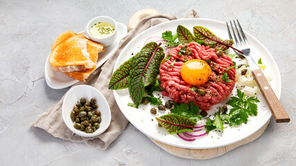 Beef steak tartare on light background. French cuisine concept.