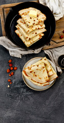 Crepes with sweet toppings on dark background.