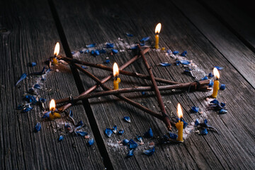Branch Pentagram - witchcraft tools of natural wood. Wooden pentagram with lighted candles in...