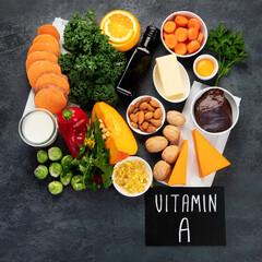 Foods high in vitamin A on dark background. - obrazy, fototapety, plakaty