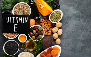Foods high in vitamin E on dark background.
