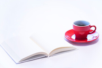 見開きの本と赤いコーヒーカップのコーヒー(白背景）