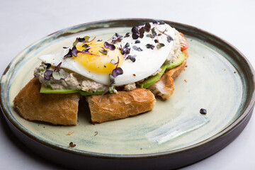 Fried egg served with vegetables on a toast