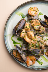 Plate of black seafood pasta with shrimps, mussels, squid