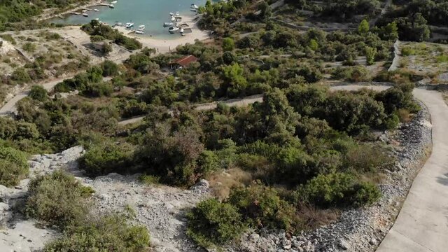 Aerial couple hike down hill to ocean, forward tilt up.