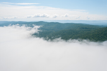 Flying through the clouds above mountain tops. High peaks wonderful morning sunrise natural Landscape