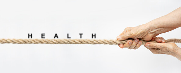 Health concept with wrinkled hands pull the rope towards themselves with text Health.