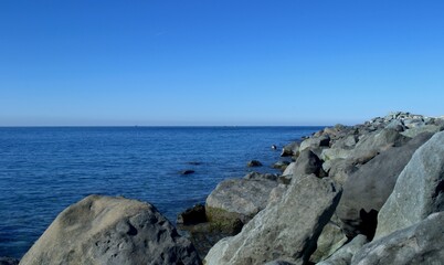 Fototapeta na wymiar Blue sea and sky. There is a stone bank on the side. The Black Sea