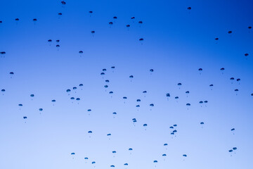 Multiple people jumping from an airplane in parachute