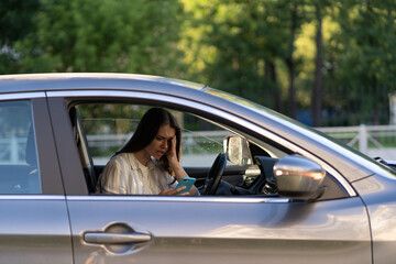 Frustrated girl cry reading sms message in smartphone while driving car. Upset young female break up with boyfriend in traffic jam getting bad news in mobile phone. Unhappy sad woman driver in tears