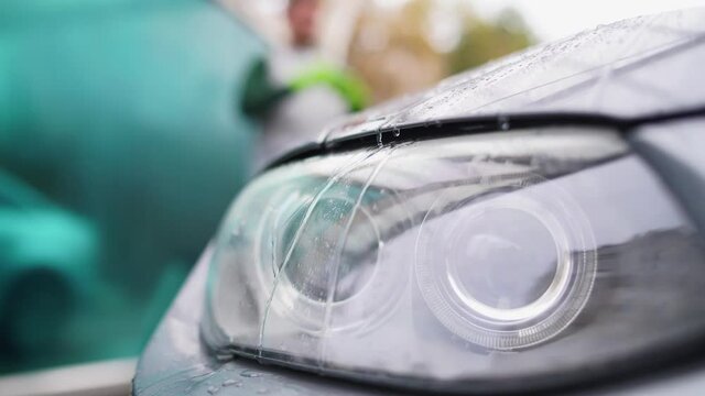 close-up of an auto headlight.Head light of BMW E92 with raindrops on close up