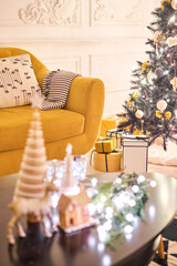 Classic apartments with decorated christmas tree and presents. Christmas evening in the light of candles and garlands. Living with fireplace and stucco.