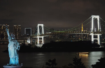 Statue of Liberty and Bridge, located in Odaiba Tokyo, with the Tokyo skyline in the background at night