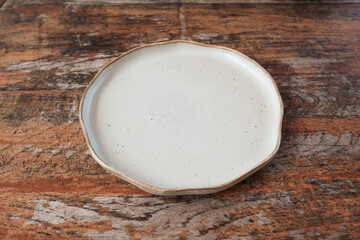 Empty ceramic shape plate for food on wooden table rustic background