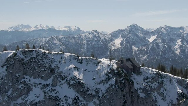 Aerial Drone Shot showing the peak of the Mountain Rauschberg flying a small circle over a Hut on top with a great parallax effect between the distance and the foreground.
