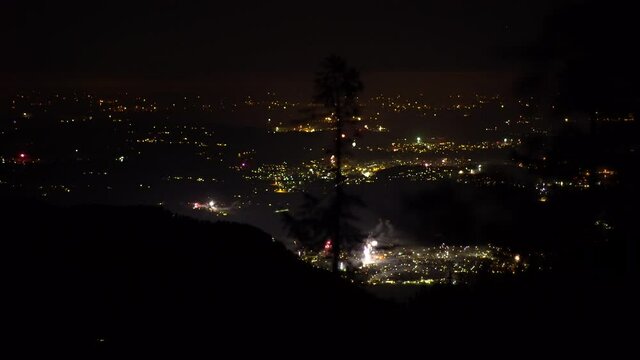 Beautiful overview of the new years eve fireworks in the year 2020 shot from on top of a mountain.