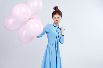 Fototapeta premium cheerful woman in a blue dress pink balloons holiday birthday
