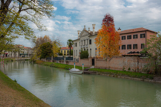 View of the Naviglio del Brenta at the town of Dolo, Italy. Autumnal image of the canal running through the city. Mysterious panorama with dramatic sky.