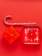 Red watch, gift, lollipop, candy on a red background.