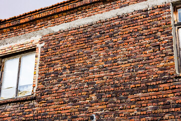 Window in red brick wall of the ancient residential building