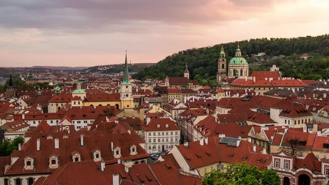 Day to night sunset timelapse from Prague, Czech Republic with a view of the red roofs of Mala Strana, St. Nicholas Cathedral and Petrin as seen from Prague Castle with sunset clouds to evening blue
