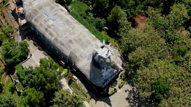 Chicken style church building with real looking head, aerial orbit view