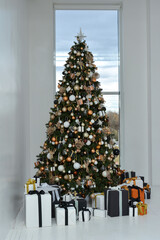 The interior of the Christmas room. Christmas tree with boxes of gifts near the window.Happy New Year! Christmas mood.