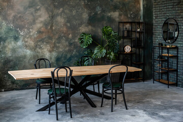 The dark loft has wooden table black chairs, stylish clock rack. Grunge wall in green-gray color....