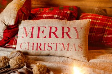 There are festive red checkered pillows on the burlap bedding with the words Merry Christmas. Home...
