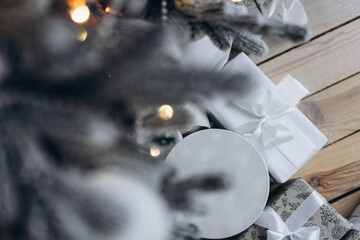 a gift on the background of a decorated Christmas tree, bokeh from a garland, a festive atmosphere