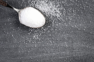 Teaspoon with white sugar. Black chalk board