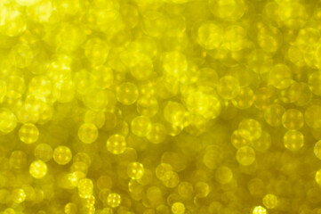 Blurred background with round bokeh in golden color. Selective focus. Bright bokeh in pattern. Bright ligts. Abstract blurred background.