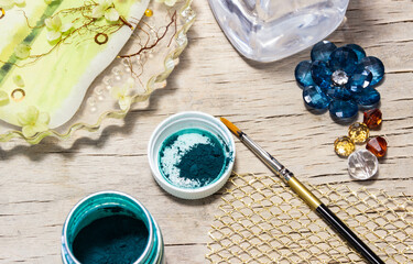 a green color for epoxy resin products, beads, a brush and a fragment of a handmade panel