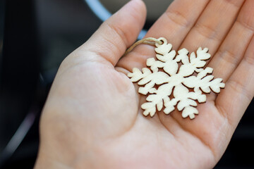 wooden snowflake in woman's hand. christmas holiday,winter time. eco fir tree toy for hanging. wood...