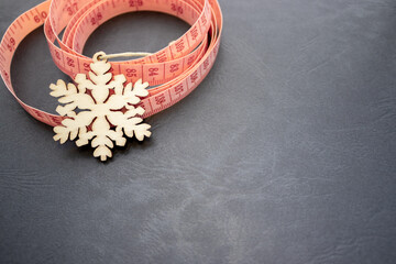 pink measure tape isolated or in woman hand. metric scale. curly circle shape soft tape for sewing.body measurement fitness weight loss concept, space for text advertising banner.snowflake wooden eco 