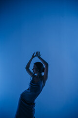 beautiful girl in a dress, blonde hair, dancing on a colored background with a pattern