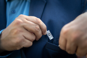 A young businessman guy holds a small bill in his hand as a symbol of declining income. Small...