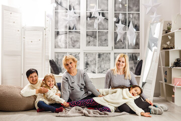 Fototapeta premium happy young family holding christmas gift and smiling