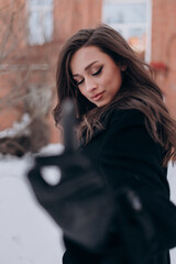 Fototapeta na wymiar beautiful girl, dark hair, winter, walking around the city, black coat