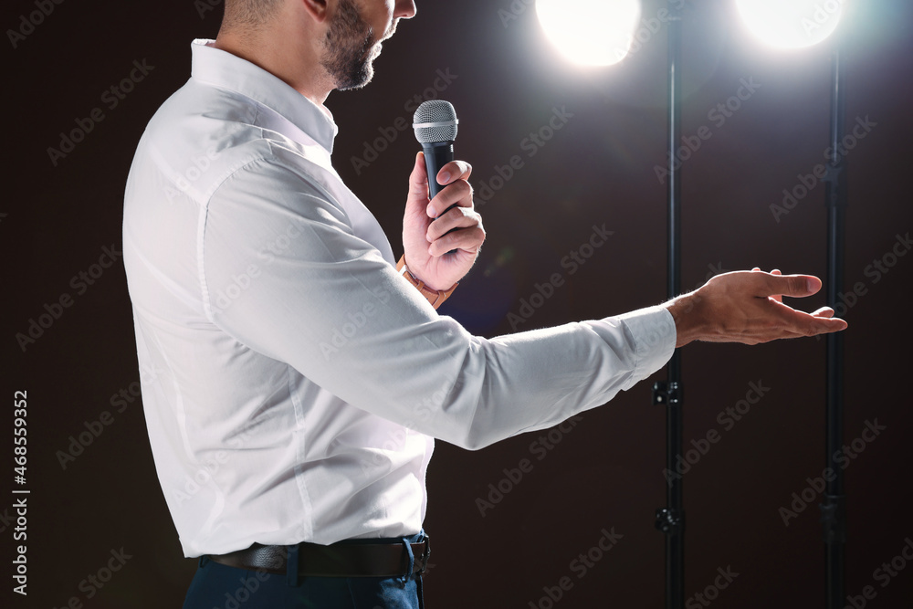Wall mural motivational speaker with microphone performing on stage, closeup