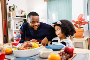 African American family. Merry Christmas. Happy family are having dinner at home. Celebration holiday and togetherness near Christmas tree.