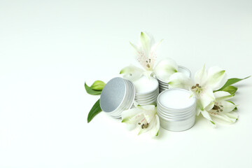Eco lip balm and flowers on white background