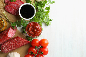 Сoncept of tasty food with salami sausage on white wooden background