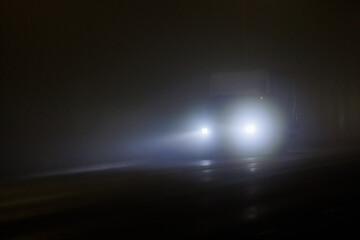 defocused alone minivan moving on empty night foggy road