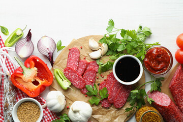 Сoncept of tasty food with salami sausage on white wooden background