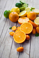 Fresh citrus fruits whole and halved on wooden board